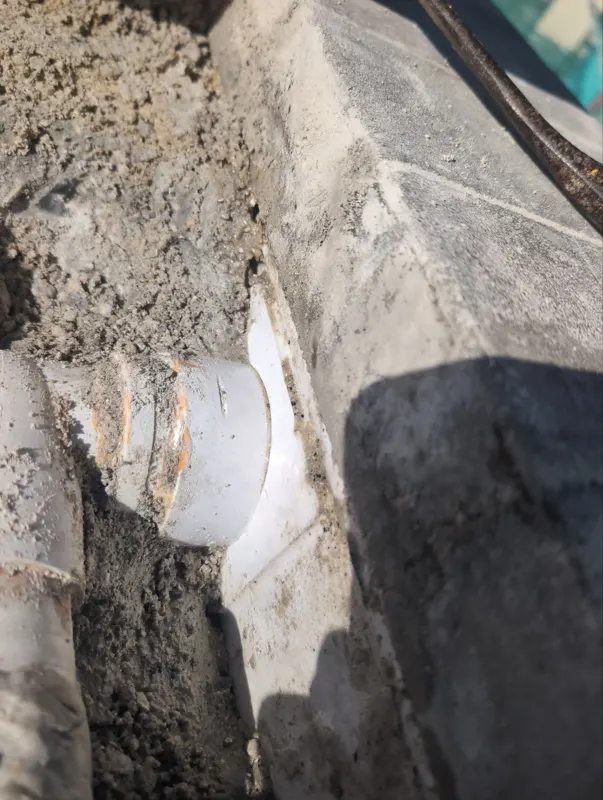 Return line fitting exposed behind a sheer descent under a pool deck