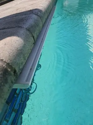 Sheer descent water feature along the edge of a pool