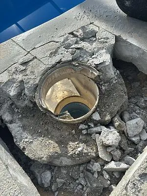 Old cracked pool skimmer exposed in broken concrete