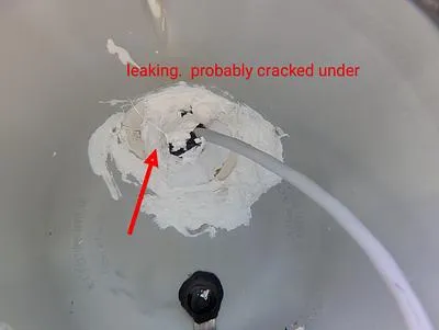 Pool light niche with old epoxy and an arrow at the leak