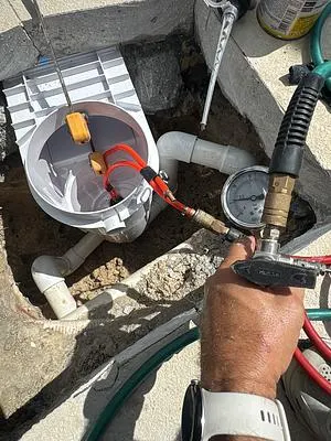 Technician testing new skimmer plumbing with a gauge