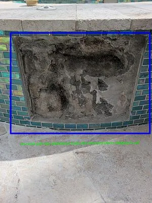 Plaster and tile chipped out around a crack