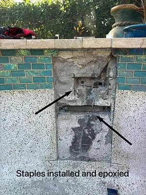 Anchors set in epoxy across a crack, marked with arrows