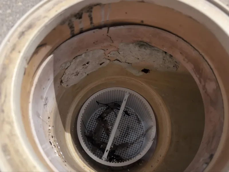 Inside of a pool skimmer with a large old patch over a crack