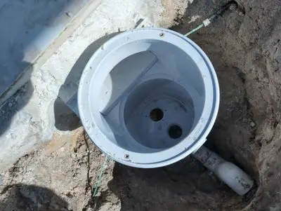New white pool skimmer set in the ground