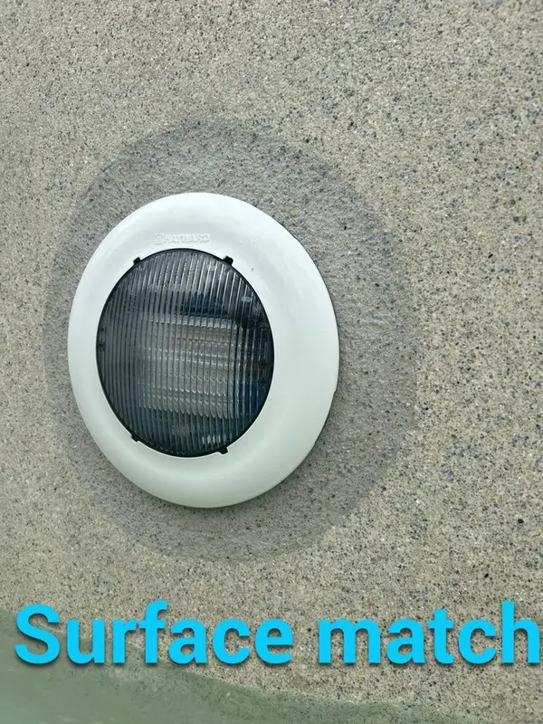 Pool light installed with the surface matched around it