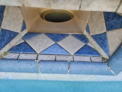 Pool skimmer throat with holes in the grout line