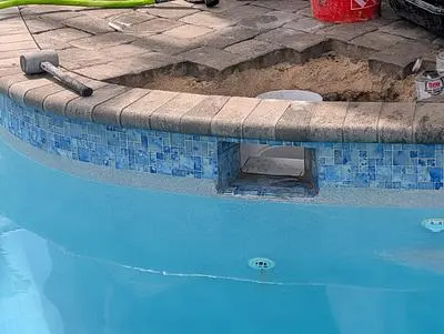 Pool wall with the skimmer throat open and pavers lifted