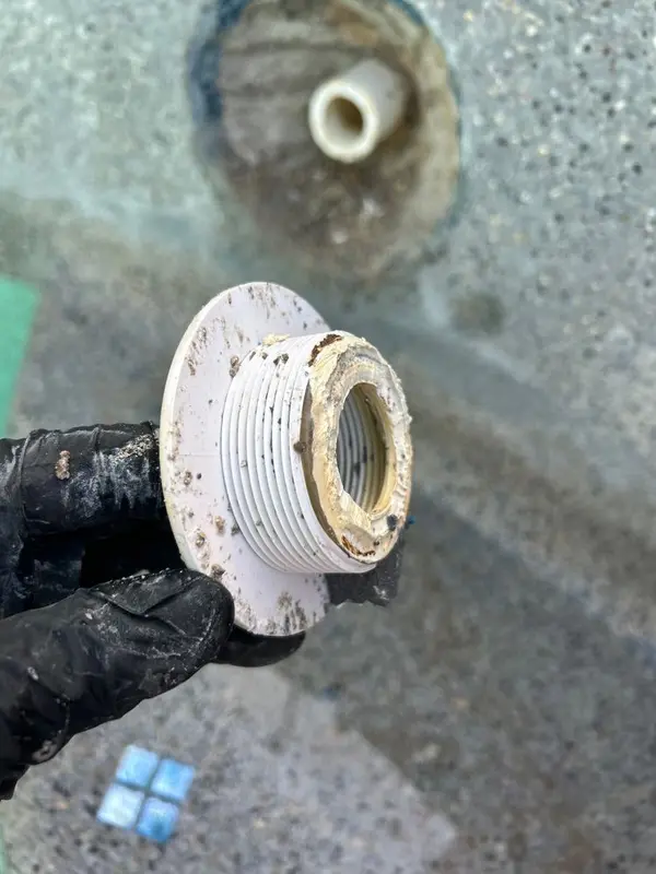 Gloved hand holding the broken return wall fitting