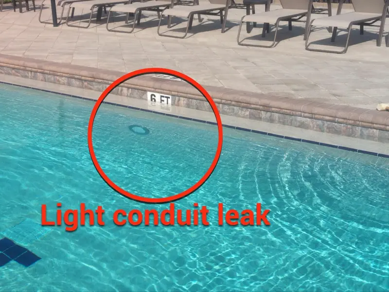 Community pool wall with a circle around a leaking light