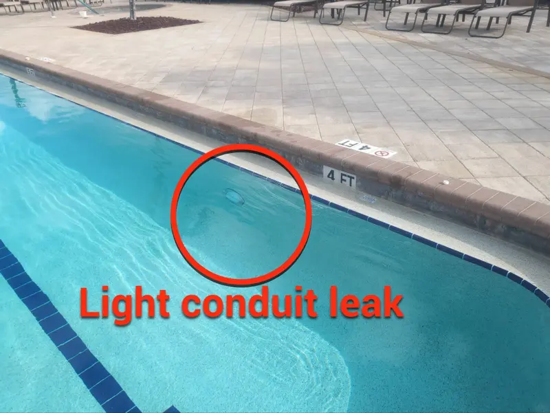 Community pool wall with a circle around a second leaking light