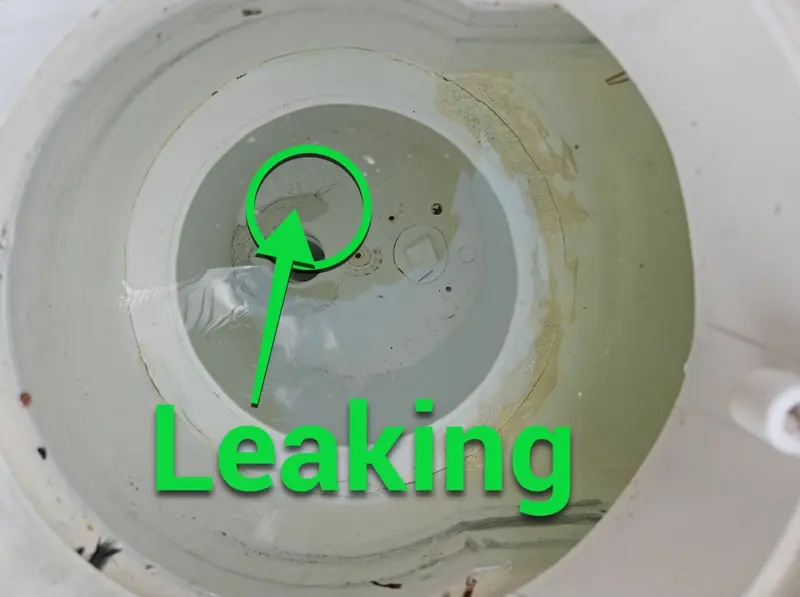 Inside a pool skimmer with an arrow pointing to the leak