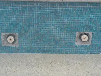 Two spa jets in glass tile with the area around them cut out