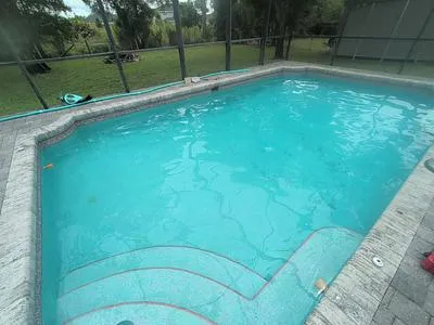Pool with a paver deck inside a screen enclosure in North Fort Myers
