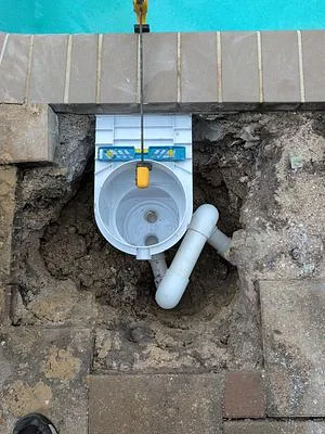 New white pool skimmer set level in the deck opening