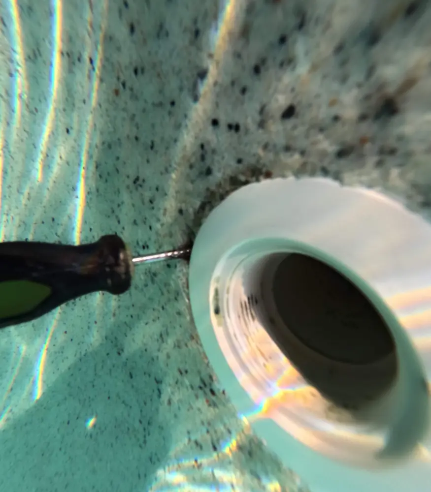 Underwater view of a pool wall fitting being tested for a leak