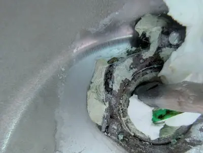 Tech applying epoxy at the conduit inside a pool light niche