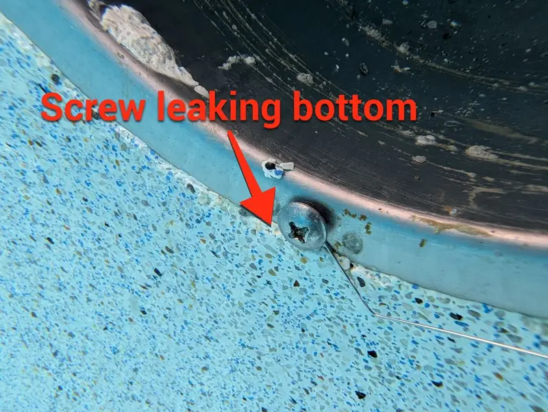 Pool light niche with an arrow pointing to a leaking screw at the bottom