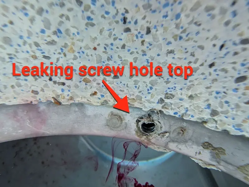 Pool light niche with an arrow pointing to a leaking screw hole at the top