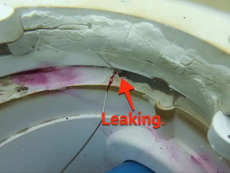 Dye pulling into a crack, marked Leaking