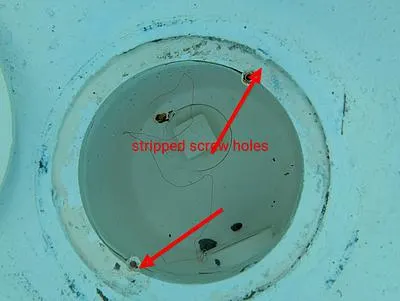 Main drain with arrows pointing to stripped screw holes